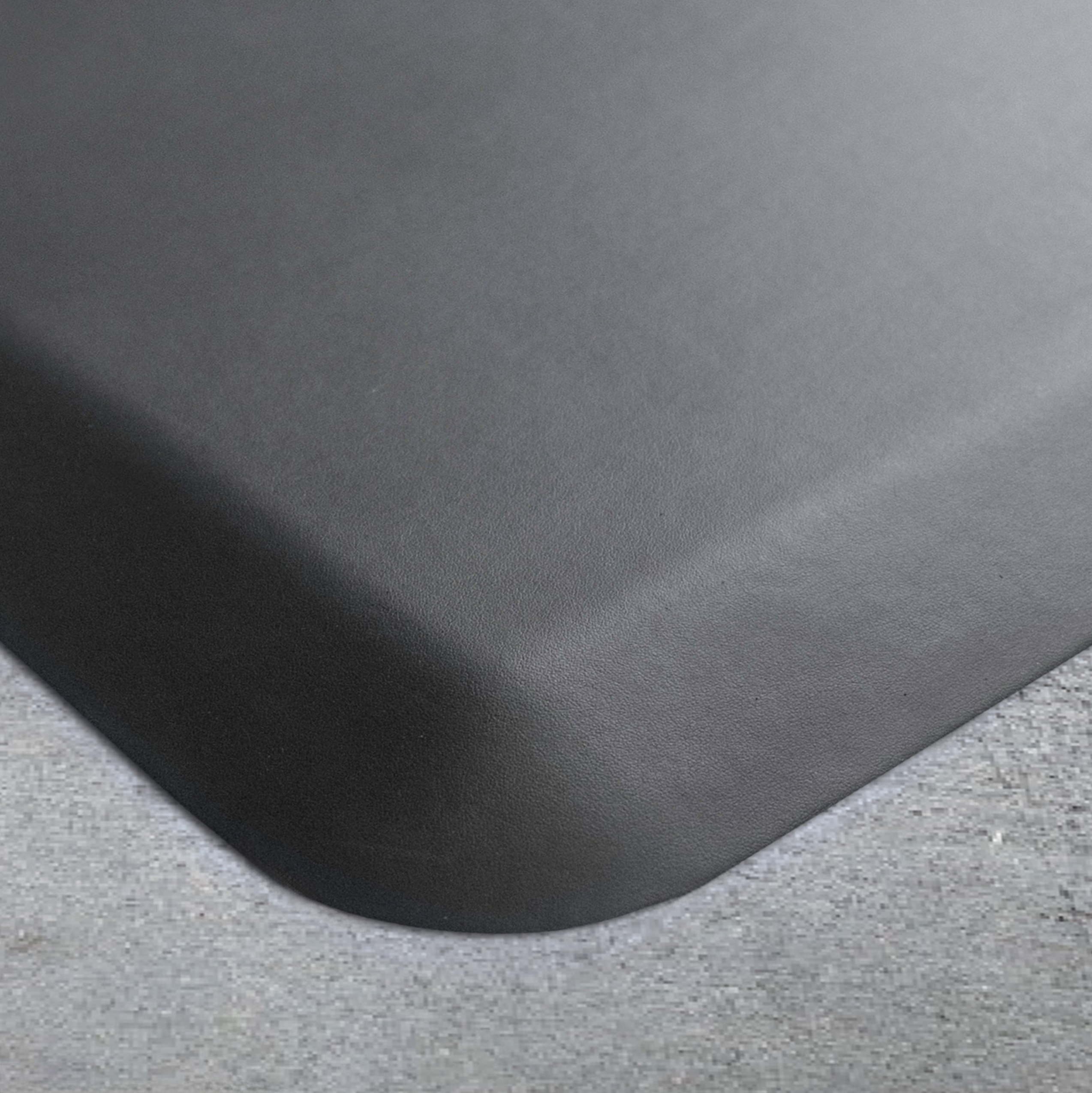 Up close corner of a gray Supreme mat on a concrete floor.